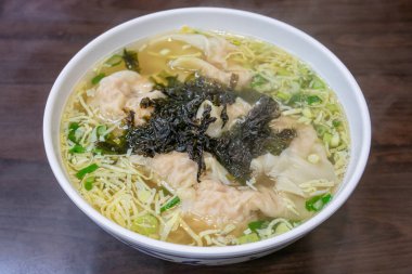 Tayvan 'ın Taipei kentindeki bir restoranda, ahşap masada yosunlu Tayvan usulü kıymalı Çin mantısı çorbası..
