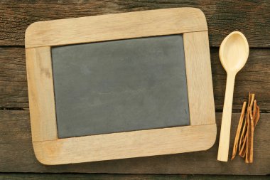 Kayrak chalkboard ve eski ahşap plakalar üzerine tarçın tahta kaşıkla