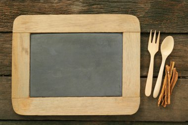 Tahta kaşık ve çatal ve eski ahşap plakalar üzerine tarçın kayrak kara tahta