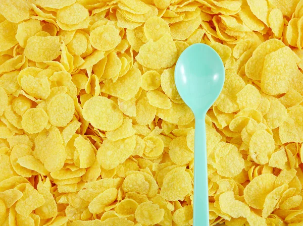 Den välsmakande gyllene cornflakes och plastsked — Stockfoto