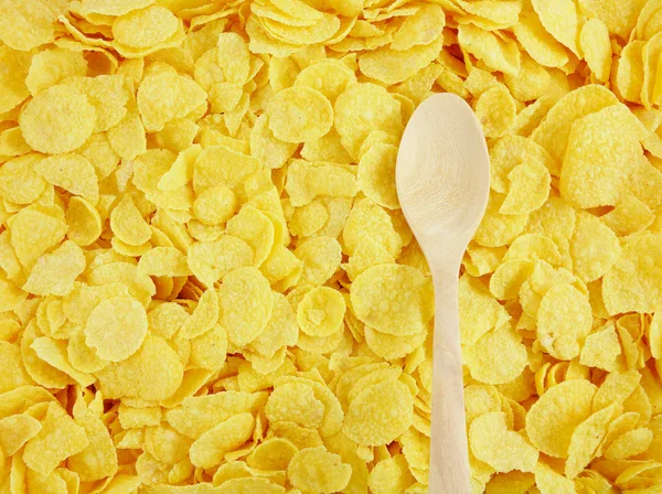 Den välsmakande gyllene cornflakes och trä sked — Stockfoto