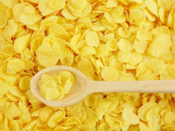 The tasty golden corn flakes and wooden spoon — Stock Photo, Image