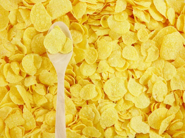 Den välsmakande gyllene cornflakes och trä sked — Stockfoto