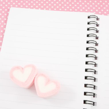 Küçük beyaz not defterindeki pembe Pamuk Kumaş ile güzel pembe kalp marshmallow