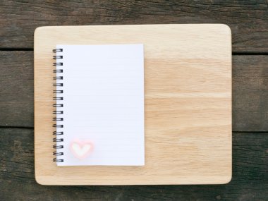 Beyaz not defteri ve güzel pembe kalp hatmi ve ahşap tahta