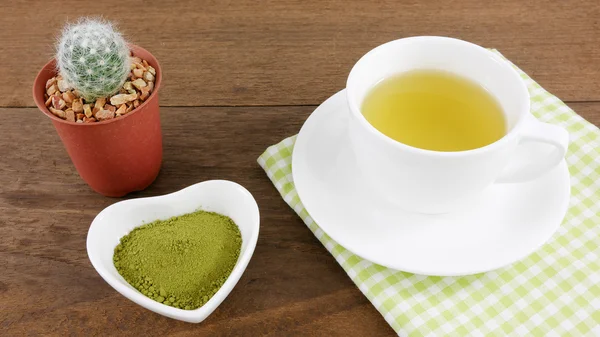 Японський matcha зелений чай порошку на керамічна серце у формі чаші і чашкою гарячого зелений чай з бавовняної тканини і мало кактус в горщик рослина — стокове фото