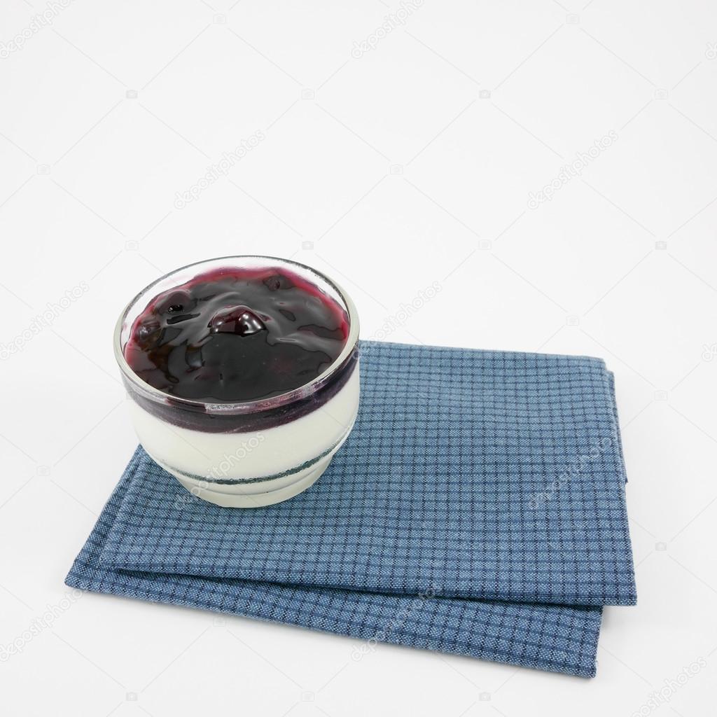 The tasty homemade blueberry panna cotta (Italian pudding dessert) in the small glass
