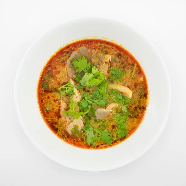 La délicieuse soupe épicée au tom yum de porc (soupe aigre-chaude) dans un bol en céramique blanche — Photo