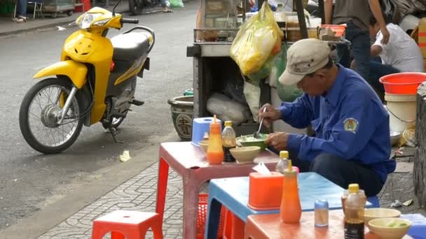 Vietnamese man eating on the street — Stock Video