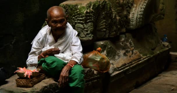 Old man Cambodian beggar monk sitting in temple offering preyer — Stock Video