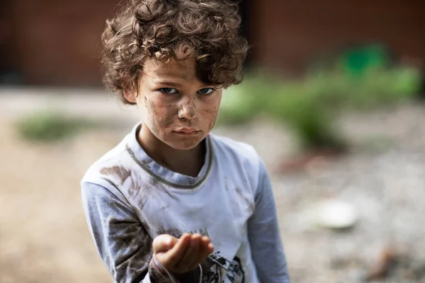 Dreckiger hungriger Junge schaut mit tränenüberströmten Augen und bittet um Hilfe — Stockfoto
