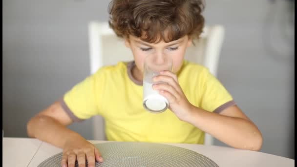 Мальчик 6 лет пьет молоко из стакана — стоковое видео