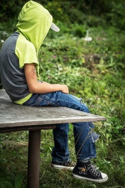 Фото грязного бездомного мальчика в порванных джинсах — стоковое фото
