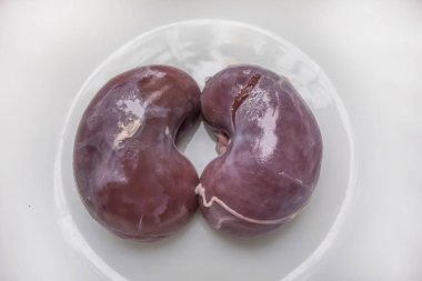 Kuzu bağırsağı. Kuzu sakatatı. Beyaz arka planda pişmeden önce yetişkin bir koç veya kuzunun çiğ böbrekleri..