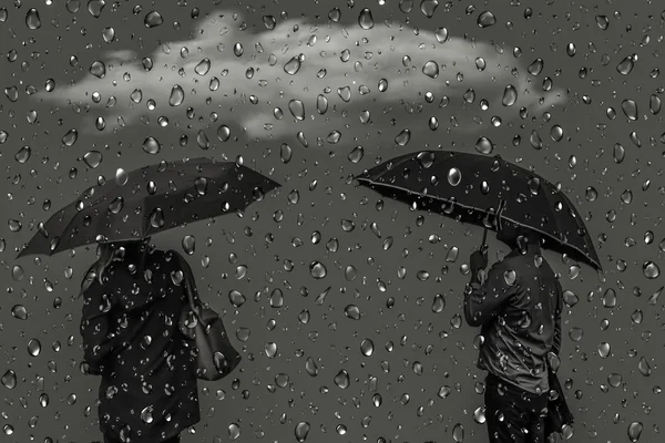 Силуэты мужчин и женщин под зонтами Лицензионные Стоковые Изображения