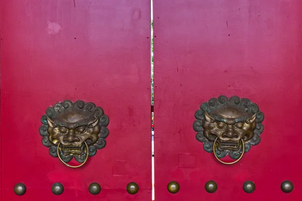 有狮子头饰的红色老式木门的细节 — 图库照片