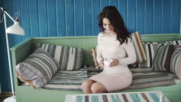 Chica feliz bebiendo café y relajarse en la cafetería, sonriendo y mirando a la cámara . — Vídeos de Stock