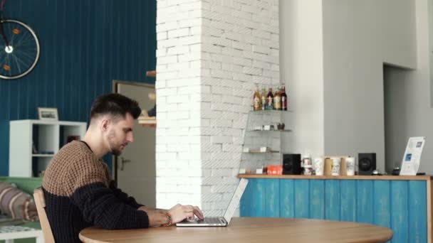 Bonito homem trabalhando com laptop no café — Vídeo de Stock