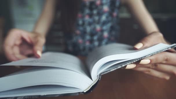 Menina vira uma página enquanto lê um livro — Vídeo de Stock