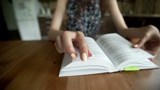 Жіноча рука читає книгу в приміщенні — стокове відео