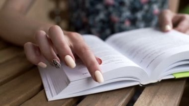 Kadın bir kağıt kitap okuma sayfaları leafing rahatla