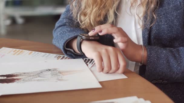 Une jeune femme artiste faisant des gestes sur un dispositif portable smartwatch informatique — Video