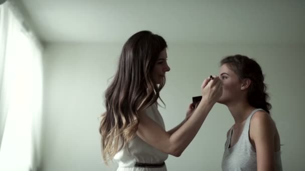 Maquilladora y modelo en un gran estudio blanco — Vídeos de Stock
