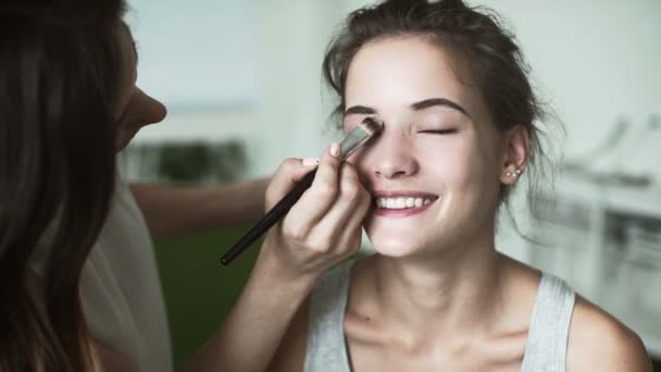 Jonge mooie vrouw en make-up artiest. meisje glimlachend — Stockvideo