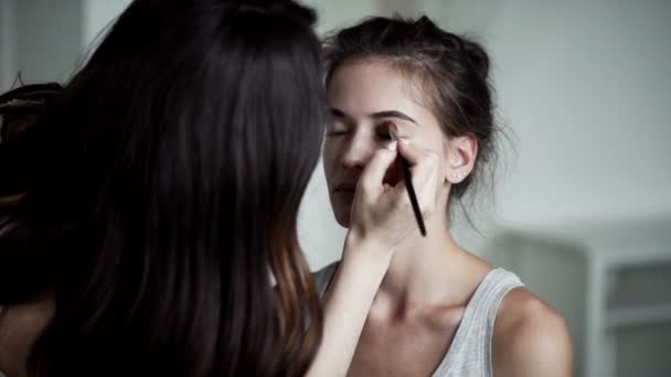 Maquillaje artista aplicando maquillaje de pestañas a los modelos de ojo. Vista de cerca . — Vídeo de stock