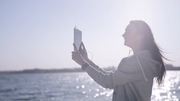Mujer feliz llega a la costa, toma autorretrato con tableta — Vídeos de Stock