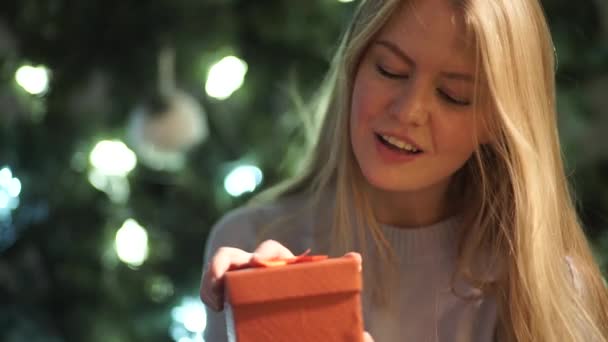 Menina beleza abre caixa de presente de Natal e olha para a câmera — Vídeo de Stock