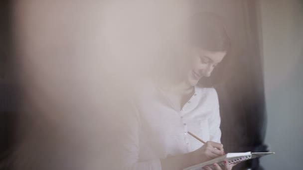 Hermosa chica por la mañana escribiendo notas en el diario. Sueña y sonríe — Vídeos de Stock