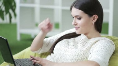 Gülümseyen dizüstü bilgisayar başında oturan kadın. Güzel iş kadını