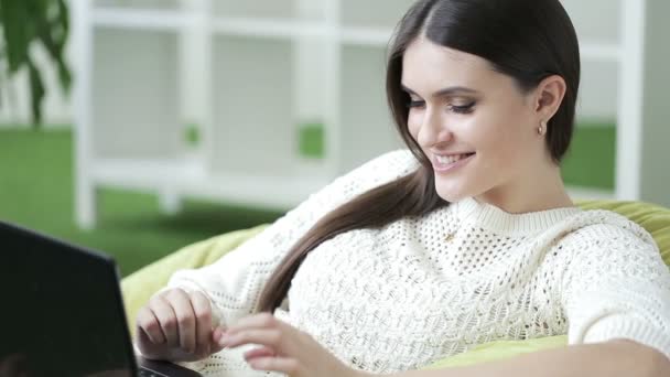 Mulher sorridente sentada em frente ao computador portátil. Mulher de negócios bonita — Vídeo de Stock