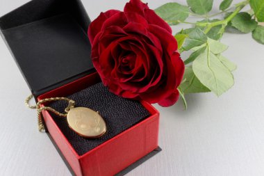 Kırmızı gül ve altın madalyon hediye kutusunda