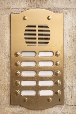 Brass intercom on a marble facade clipart
