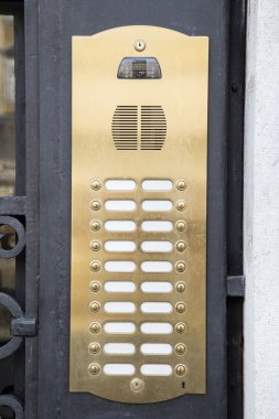 Brass intercom on a metal door clipart