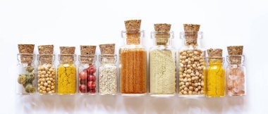 Beyaz arka planda küçük şişelerde baharatlar