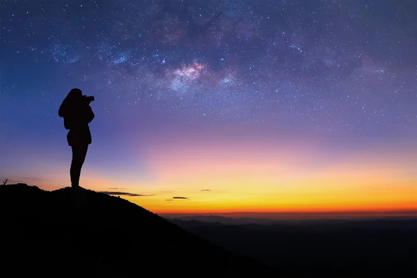 Silhouette einer Frau macht das Milchstraßenfoto auf dem Gipfel des Berges vor Sonnenaufgang. — Stockfoto