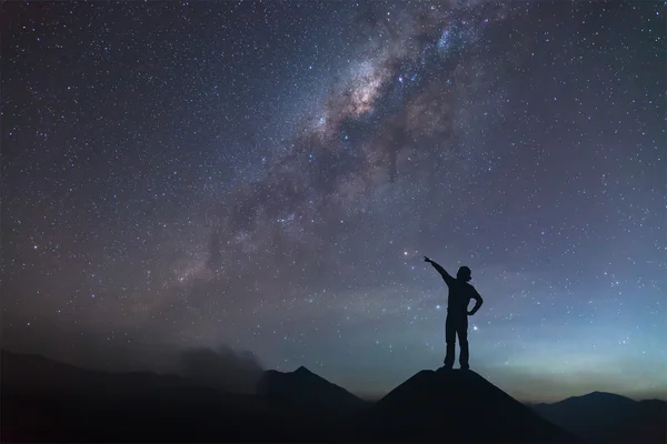 Woman is standing on the hill and pointing the Milky Way. — Stock Photo, Image