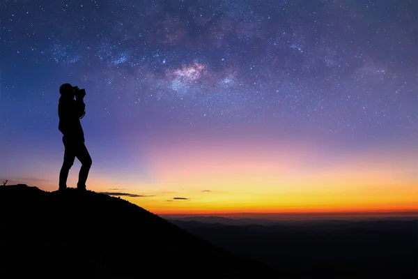 Silhouette einer Frau macht das Milchstraßenfoto auf dem Gipfel des Berges vor Sonnenaufgang. — Stockfoto