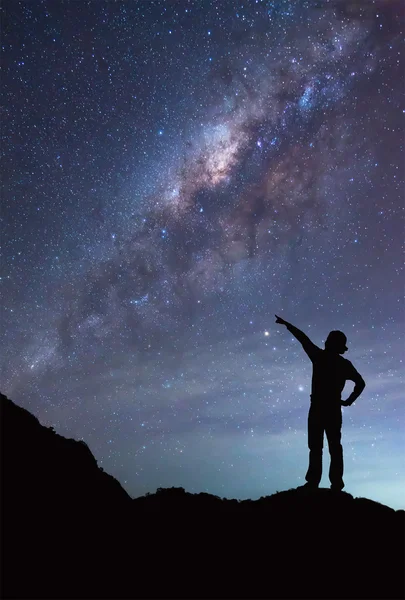 O fată stă lângă galaxia Calea Lactee îndreptată spre o stea strălucitoare. . — Fotografie, imagine de stoc