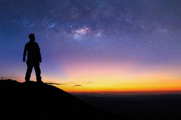 Adam silüeti dağın tepesinde duran ve Samanyolu doğmadan görmek için zevk.