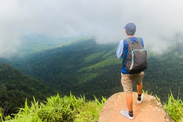 Νεαρός άνδρας backpacker Απολαύστε τη θέα στην κορυφή του βουνού σε συννεφιασμένη μέρα. — Φωτογραφία Αρχείου