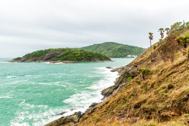 Phuket, Tayland bulutlu gökyüzü altında kayalık sahil.