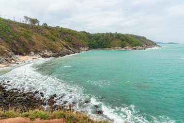 Phuket, Tayland bulutlu gökyüzü altında kayalık sahil.