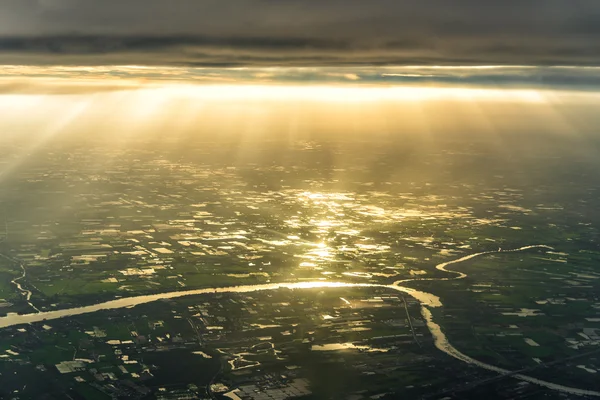 Вид с воздуха на реку и сельскохозяйственные угодья с лучами солнечного света — стоковое фото