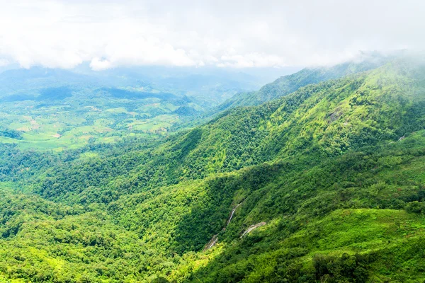 Вид с воздуха на водопад в зеленом горном хребте в дождевом лесу в пасмурный день . — стоковое фото