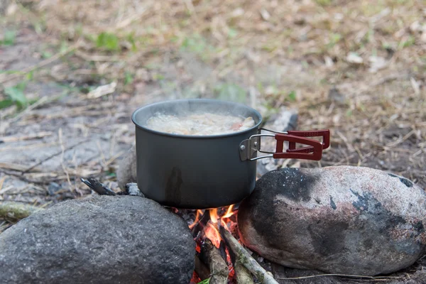 Saha koşullarında yemek pişirmek, piknikte kamp ateşinde demlik pişirmek.