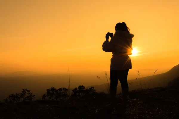 Silueta mladých žen užívajících fotografii mobilní telefon na m — Stock fotografie